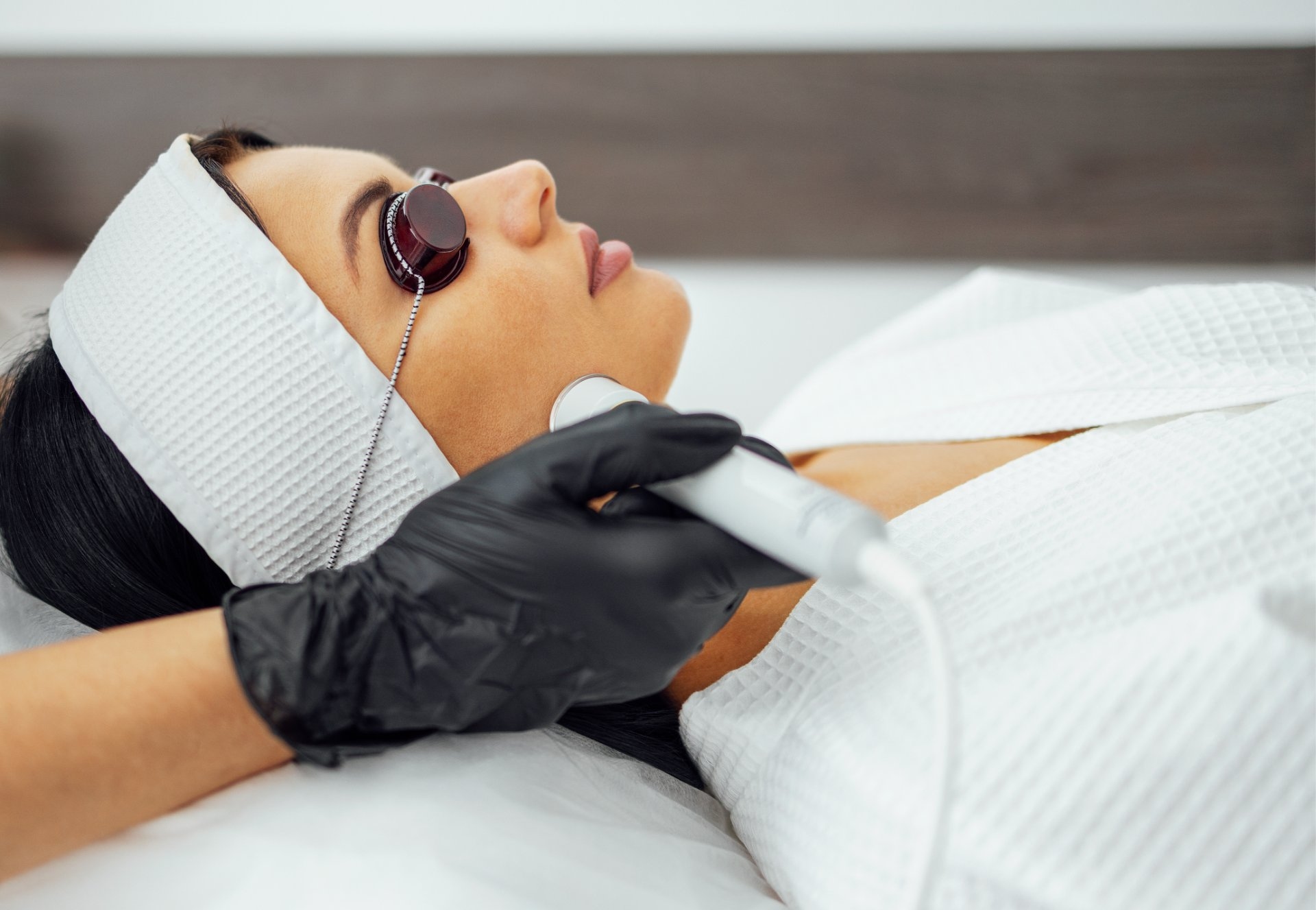 Pacientă cu ochelari de protecție în timpul unei ședințe de laser fracțional CO2 la Clinica Dr. Kurbe