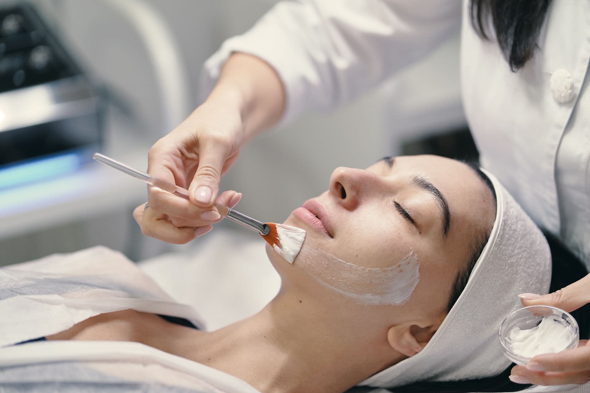 Medicul dermatolog examinează minuțios tenul înainte de aplicarea unui peeling chimic medical la clinica Dr. Kurbe