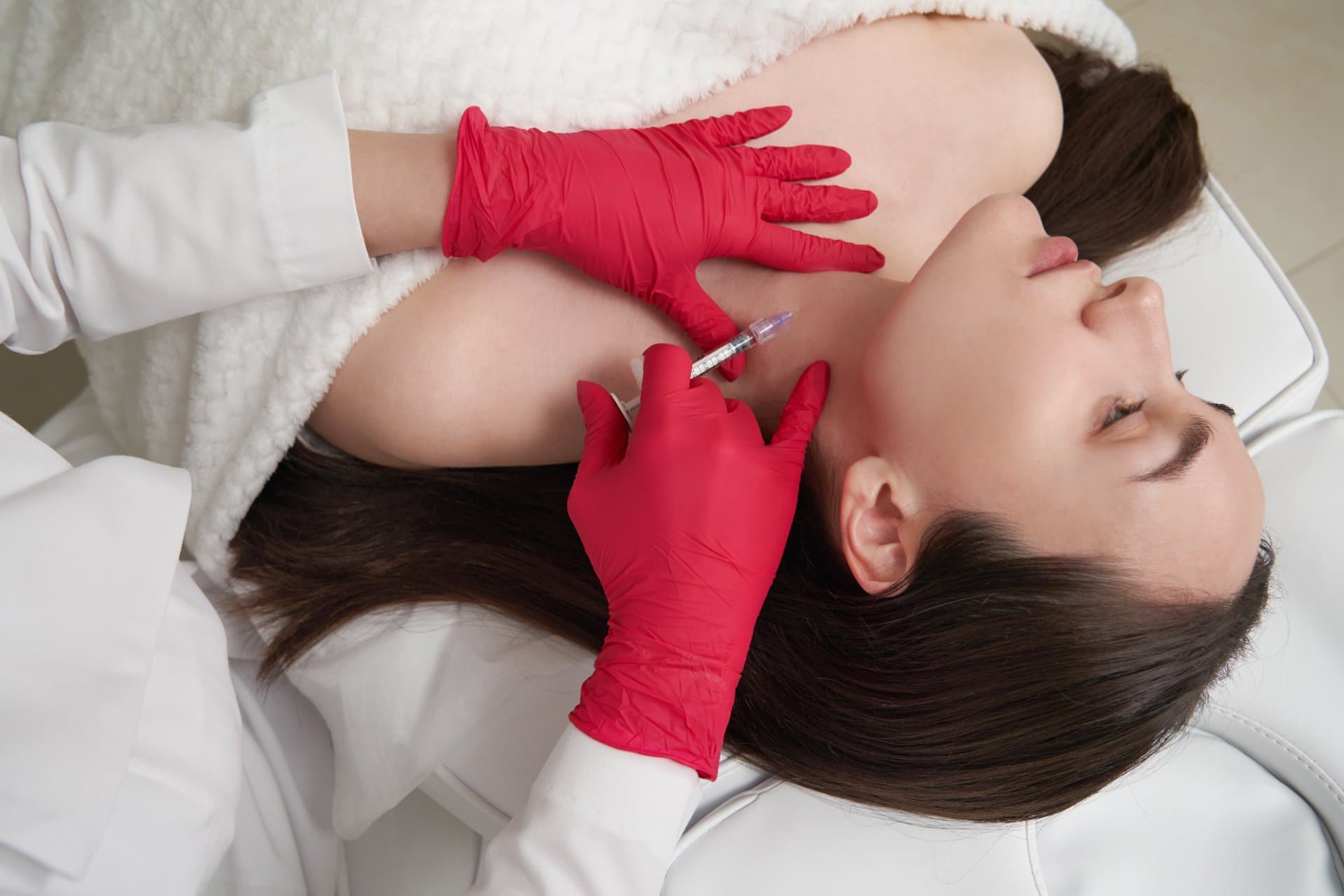 Medic injectând un tratament estetic non-chirurgical în zona pomeților unei paciente, la Clinica Dr. Kurbe